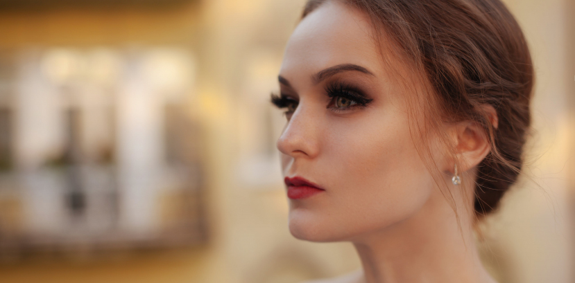 głowa młodej kobiety zapatrzonej w dal, ustawiona bokiem, włosy upięte