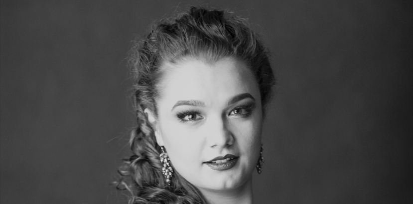 młoda kobieta patrzy na wprost, lekko się uśmiecha, włosy kręcone upięte i położone na jednym ramieniu