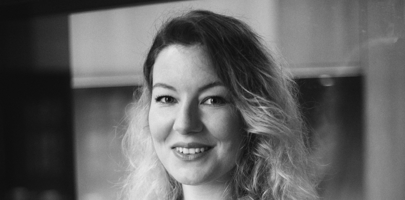 młoda kobieta w rozpuszczonych włosach patrzy na wprost, uśmiecha się