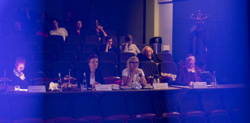 ciemna sala, ludzie siedzący na widowni